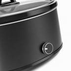 Close-up van de draaiknop en de rand van het glazen deksel van de slowcooker