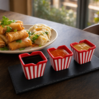 Dipkommetjes met sojasaus, chilisaus en pindasaus naast loempia's en dumplings