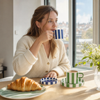 Vrouw drinkt koffie uit een gestreept kopje aan de ontbijttafel