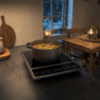 Inductiekookplaat met een pan soep in een vakantiehuiskeuken