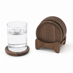 Walnoten onderzetter met een glas water en de houder met de overige onderzetters